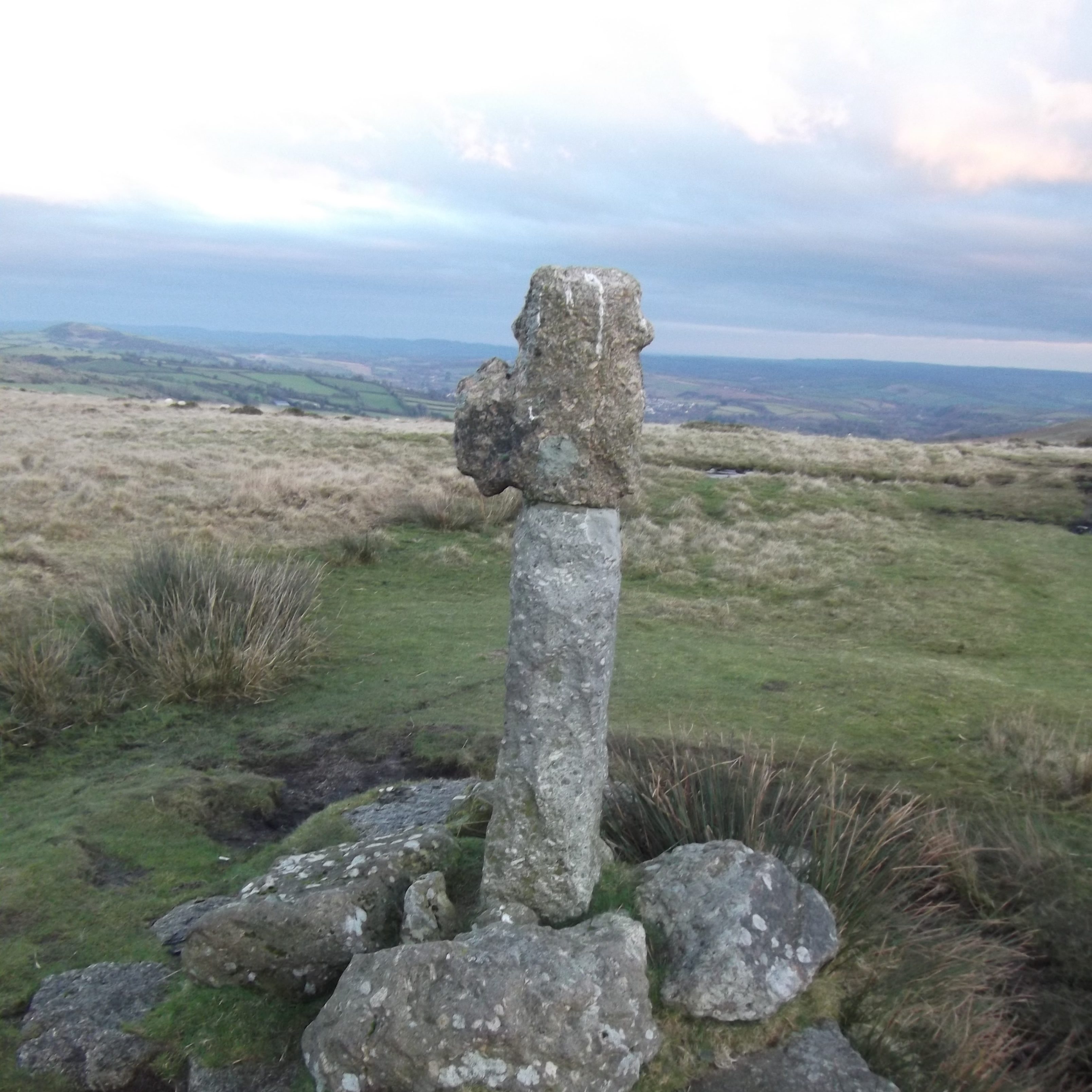 An ancient stone cross with a view over Dartmoor's rolling hills beyond